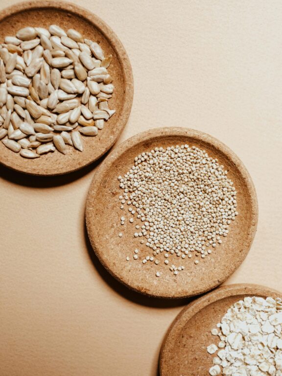Organic seeds and grains in wooden bowls at Busy Bee Organics